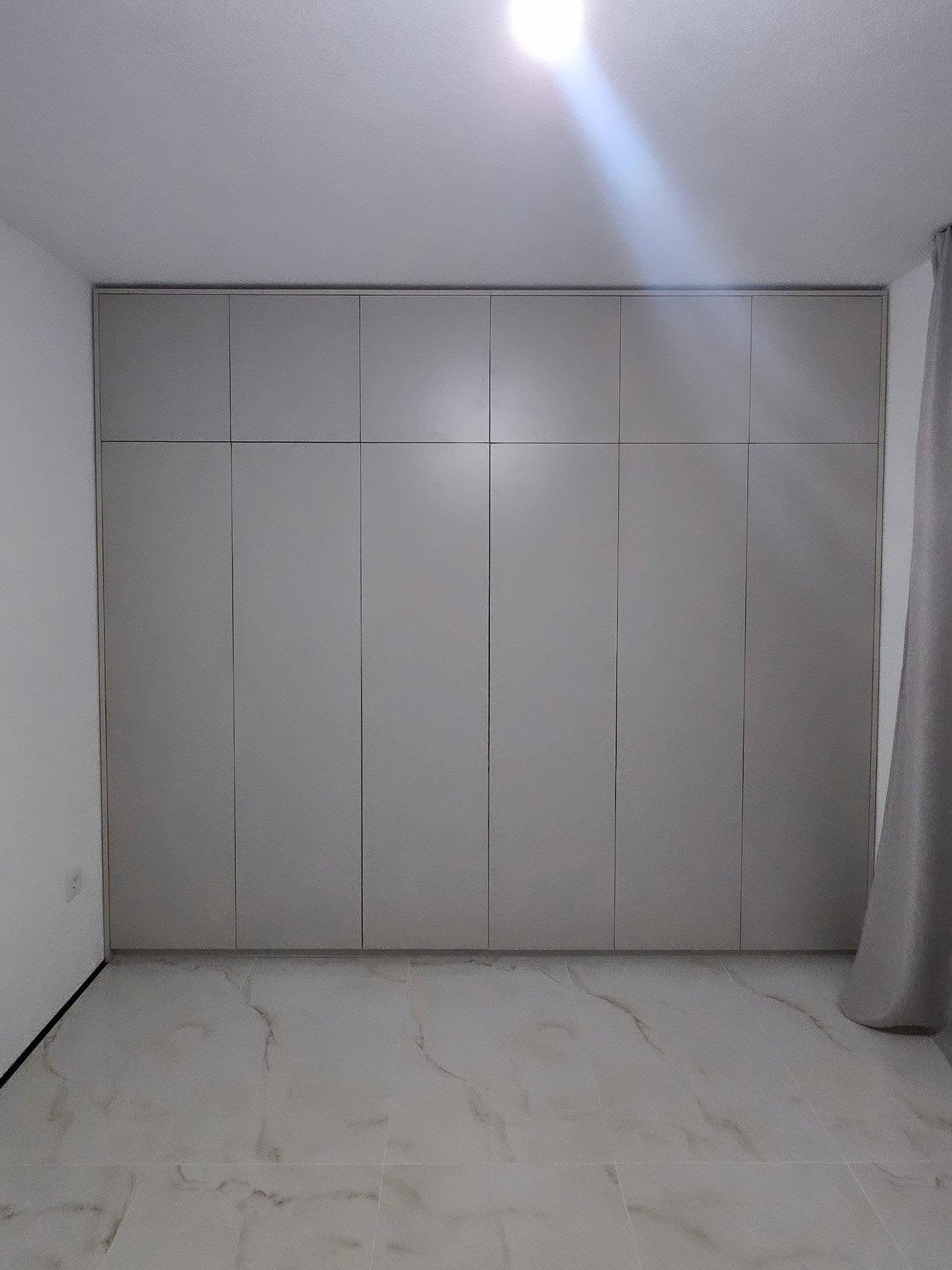 Ugradni plakar u boji kašmira, od zida do zida i od poda do plafona, bez rukohvata